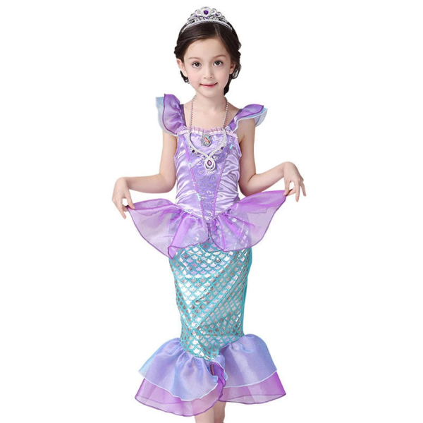 Kleines braunes Mädchen mit einem Kleid der kleinen Meerjungfrau und einem Steuerrad in den Händen