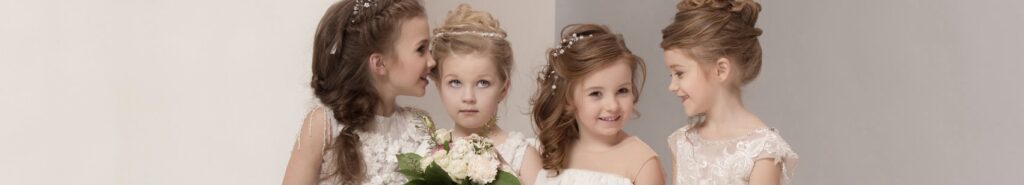 Kleine Mädchen in Brautkleidern mit einem Blumenstrauß in den Händen