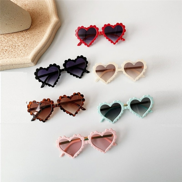 Herzförmige Sonnenbrille auf einem mehrfarbigen Tisch