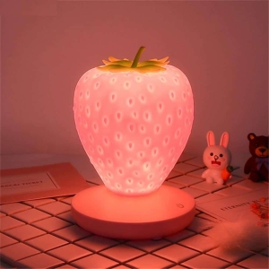 LED-Nachtlicht in Form einer Erdbeere für Mädchen. Gute Qualität und sehr originell auf einem Tisch in einem Haus