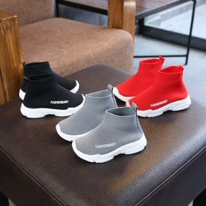 Lässige Sneakers in den Farben Rot, Schwarz und Grau für Mädchen auf einem Stuhl in einem Haus