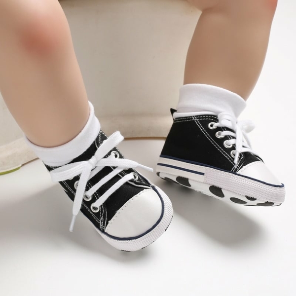 Schwarze, hohe Schnürschuhe, die von einem Kind getragen werden