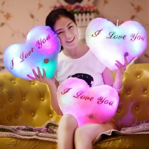 Herzförmiges LED-Plüschtier für Mädchen in mehreren Farben von einem Mädchen in einem Haus getragen