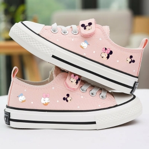 ein Paar Schuhe für Mädchen, rosafarben und mit Disney-Motiven mit kleinen Minnies, Mickeys und Donalds. Die Schuhe stehen übereinander und auf einem weißen Tisch.