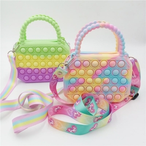 zwei Kinderhandtaschen werden nebeneinander gestellt. Sie sind beide farbenfroh und haben kleine Pop-It-Bälle und ebenso farbenfrohe Riemen