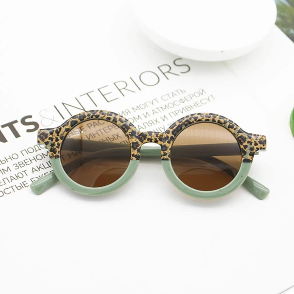 Eine Sonnenbrille mit halb grünem Rahmen und halb Tiermotiv auf einer Magazinseite