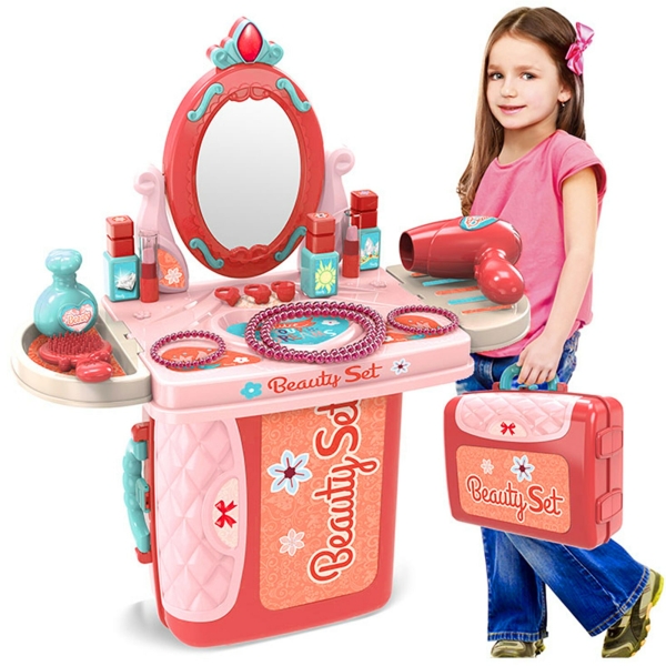 Schminktisch mit Spiegel und Zubehör in Rot und Rosa und ein kleines Mädchen steht mit dem Schminktisch in einem Koffer verpackt