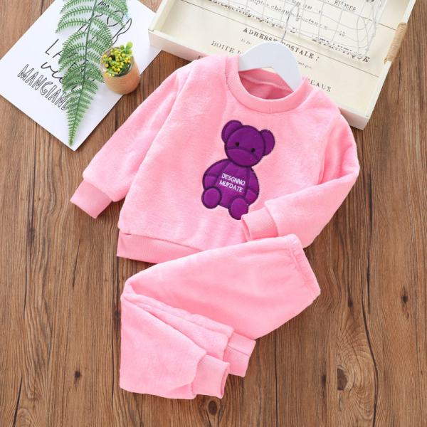 Dicker Fleece-Pyjama mit Teddybär-Motiv für rosafarbene Mädchen auf einem Tisch