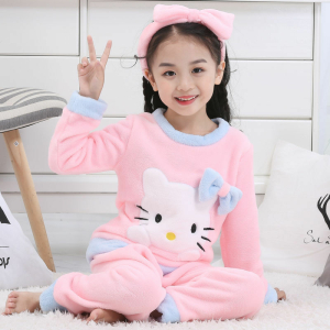 Hello Kitty Winter-Pyjama-Set aus Fleece für Mädchen, das von einem kleinen Mädchen getragen wird, das in einem Haus einen modischen Haarreif trägt