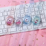 über einer Tastatur, vier durchscheinende Uhren mit kleinen Kätzchen auf dem Zifferblatt, es gibt eine weiße, eine rosa, eine blaue und eine grüne