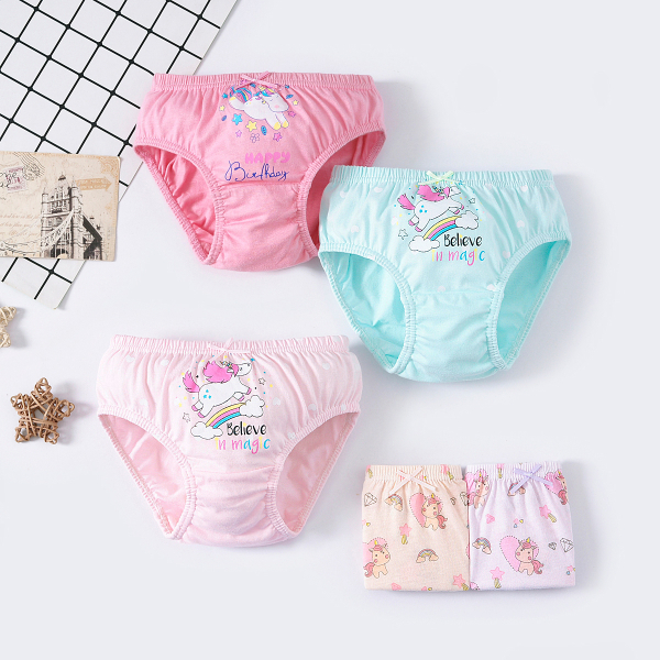 Set aus fünf Höschen auf hellem Hintergrund, darunter ein dunkelrosa Höschen oben mit dem Design eines Einhorns mit buntem Schwanz, farbigen Sternen und dem Schriftzug Happy Birthday, ein blaues und ein hellrosa Höschen unten, beide mit dem Design eines Einhorns, das über einen Regenbogen mit Sternen und Wolken läuft, und zwei ganz unten gefaltete Höschen mit mehreren Einhörnern in Mustern, Regenbogen, Diamant und Herz.