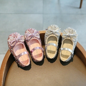 Prinzessinnen-Ballerinas mit glitzernder Fliege für Mädchen mit einem Hintergrund ein Tisch mit den Schuhen