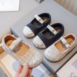 Ballerinas aus Stoff mit Glitter- und Karomuster für Mädchen mit einem grauen Schuhkarton als Hintergrund