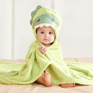 Sitzendes Baby mit einem grünen Bademantel mit Kapuze