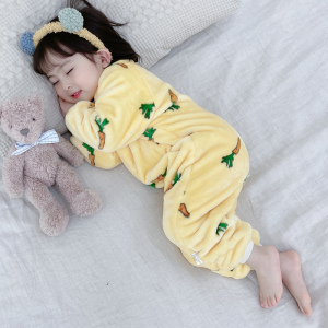 Kleines Mädchen, das in einem gelben Überanzug in einem Bett schläft, mit ihrem Kuscheltier