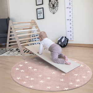 Baby spielt auf einem runden Teppich in einem Schlafzimmer