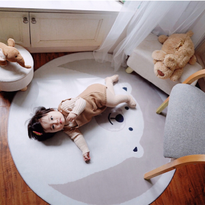 Teppich für das Babyzimmer eines Mädchens mit weißem Bärendruck und einem Baby, das auf dem Teppich liegt
