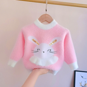 Weicher rosa und weißer Pullover mit einem Hasen auf der Vorderseite, der auf einem Kleiderbügel hängt, eine ausgestreckte Hand stützt ihn