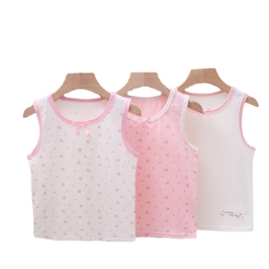 Drei rosa und weiß bedruckte Unterhemden, die auf Bügeln hängen