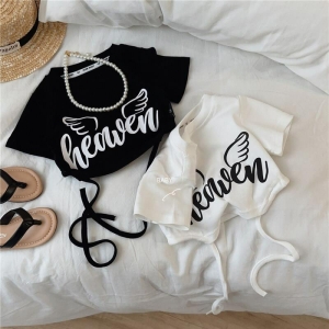 2 schwarz-weiße Crop Tops auf einem weißen Sofa, mit Accessoires rundherum