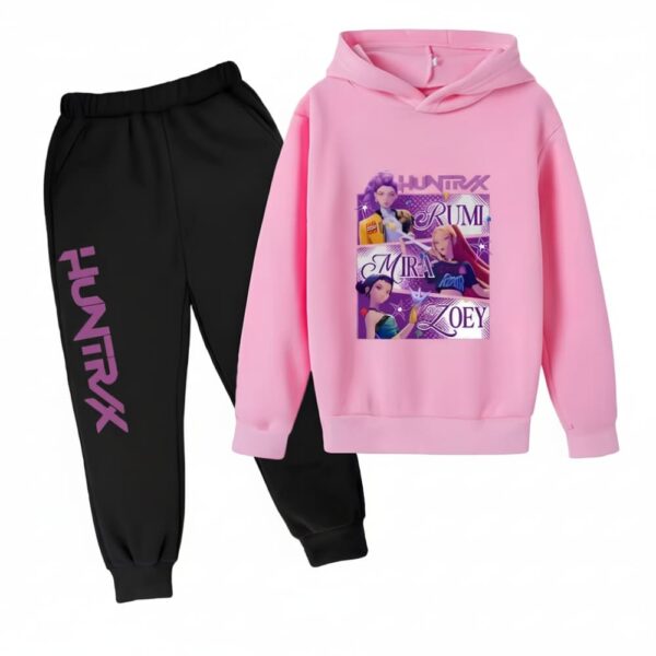 IMG_10_2025_jogging_fille_K_pop_Demon_Hunters_bicolore_1.jpg K-pop Demon Hunters Jogginganzug Mädchen zweifarbig mit einer schwarzen Hose mit einer Aufschrift "Huntrix" in lila Großbuchstaben auf einem Bein und einem rosa Sweatshirt mit Kapuze mit einem Aufdruck in der Mitte der drei Heldinnen mit ihren Vornamen. Auf weißem Hintergrund.