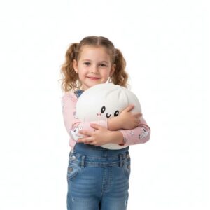 Jeune fille debout avec des couettes, portant un jean et un t-shirt rose, qui tient dans ses bras un squishy dumpling blanc.